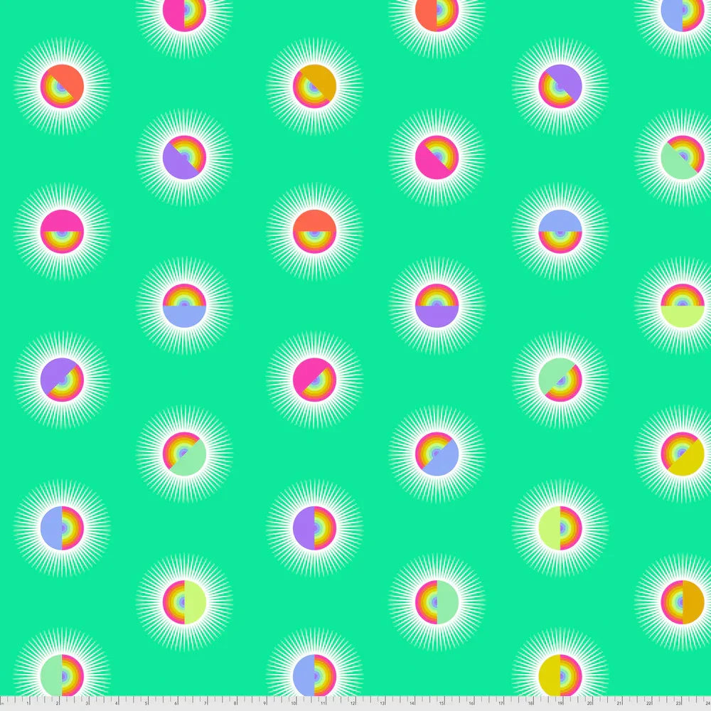 Pattern of colorful rainbow circles on a turquoise background with a ruler for scale
