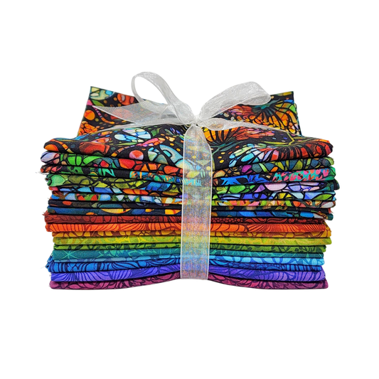 A stack of colorful fabric swatches featuring stained-glass floral designs tied with a white ribbon.