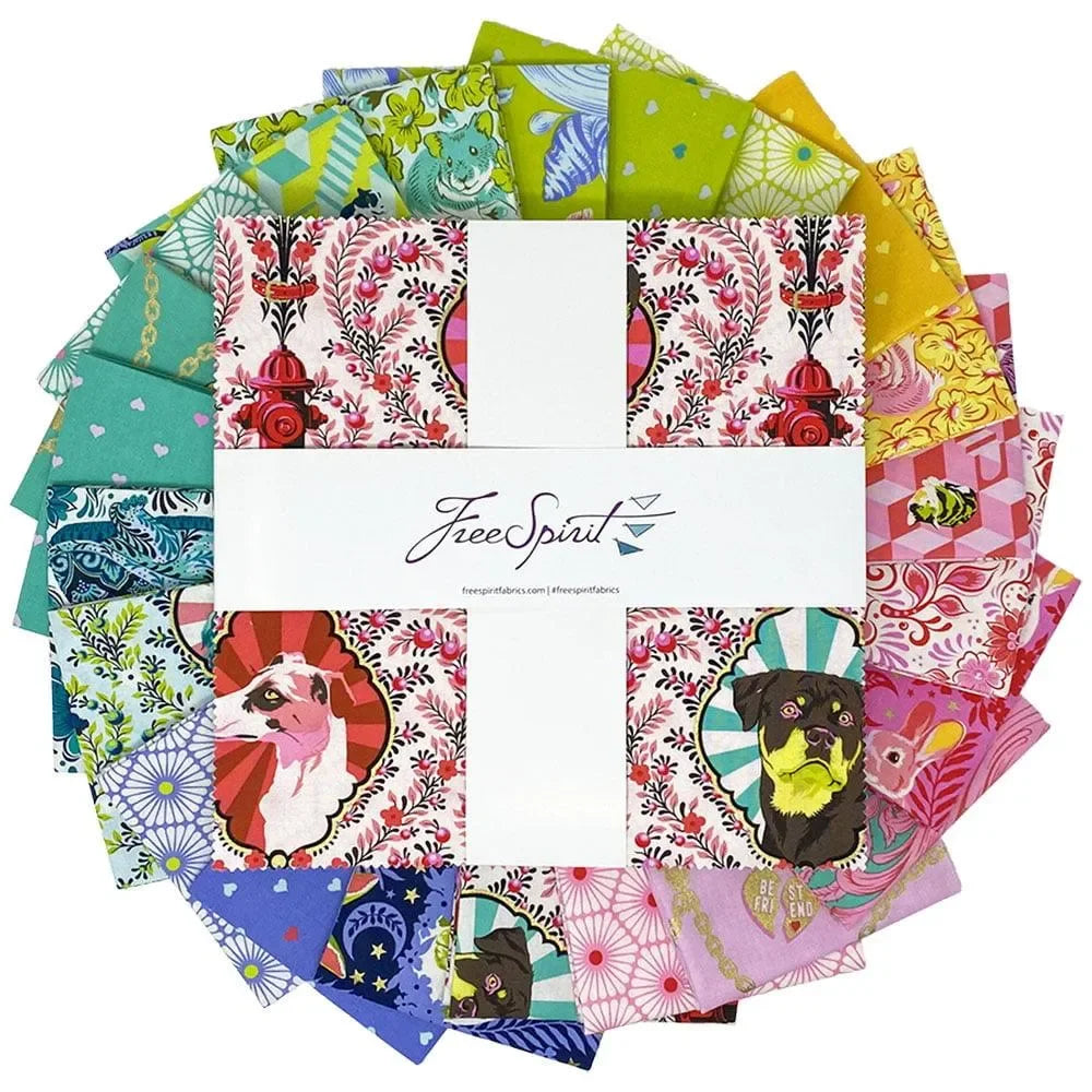 Collection of colorful fabric swatches arranged in a circle with a layer cake in the center.