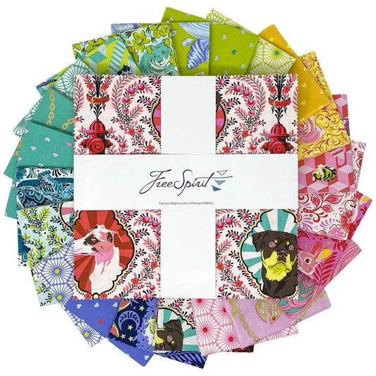 Collection of colorful fabric swatches arranged in a circle with a layer cake in the center.