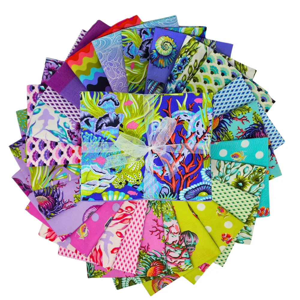 Collection of colorful fabric squares arranged in a circle with a central bundle tied with ribbon