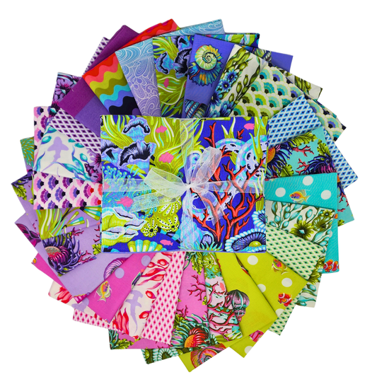 Collection of colorful fabric squares arranged in a circle with a central bundle tied with ribbon