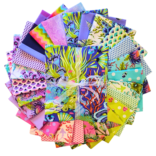 Collection of colorful fabric squares arranged in a circle with a central bundle tied with ribbon