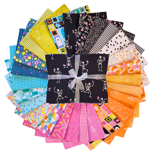Collection of colorful fabric squares arranged in a circle with a central bundle tied with ribbon