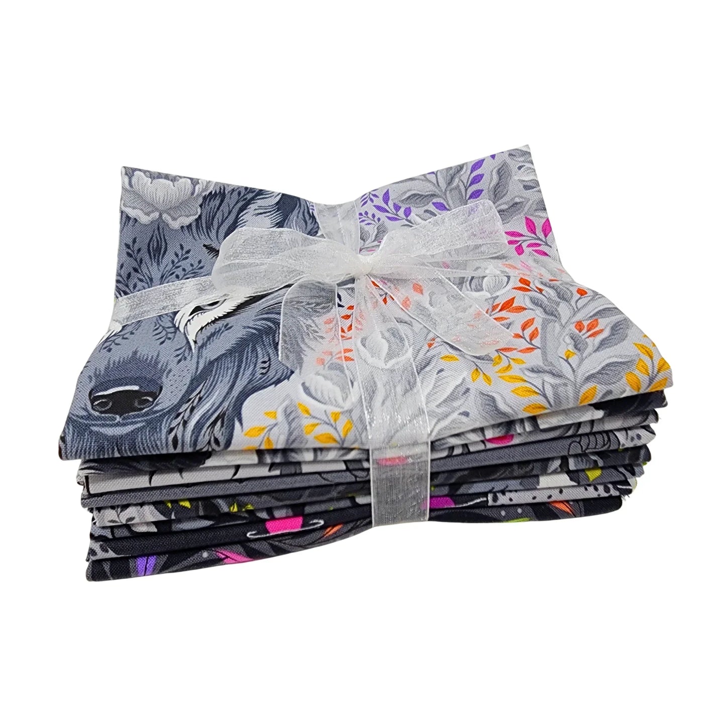 Stack of folded fabric with animals and floral patterns tied with a ribbon on a white background