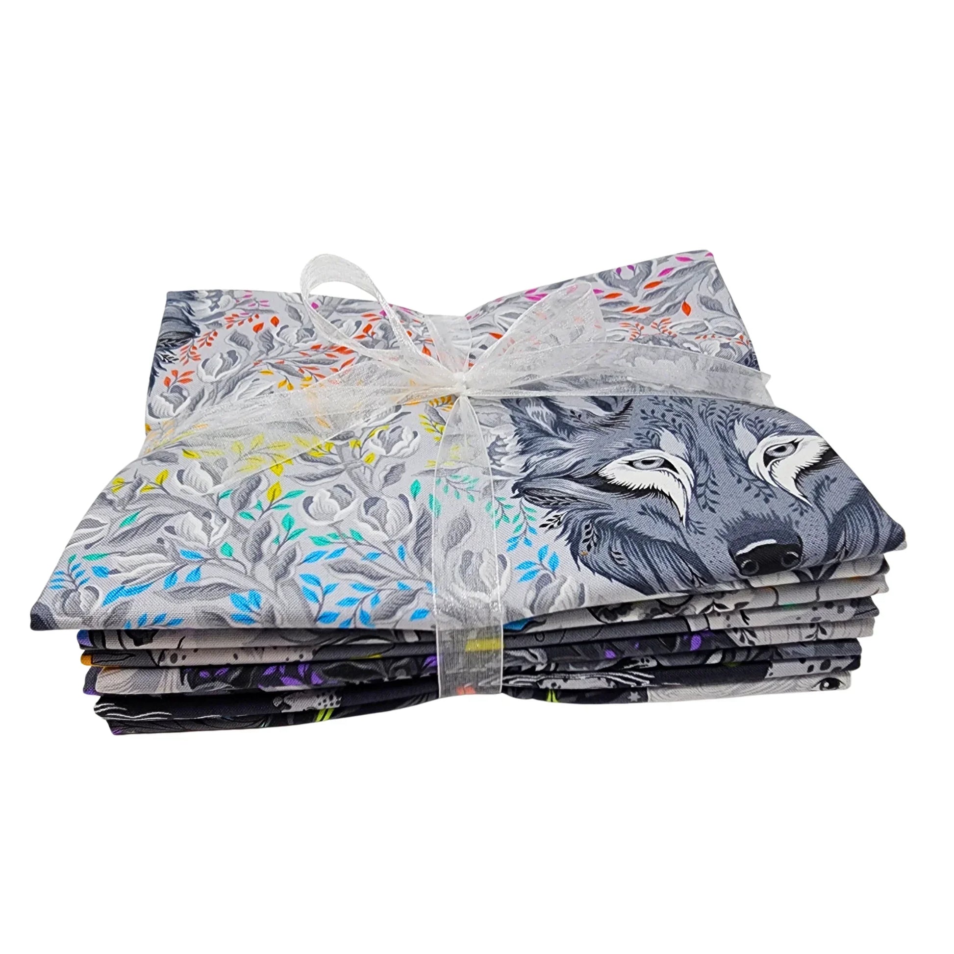Stack of fabric squares with animal and floral designs tied with a white ribbon on a white background