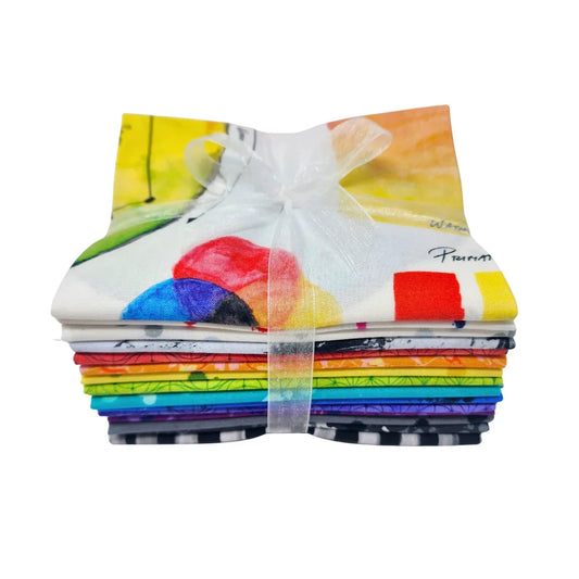 Stack of patterned fabric squares in a full rainbow spectrum tied with a white ribbon.