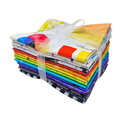 Stack of patterned fabric squares in a full rainbow spectrum tied with a white ribbon.