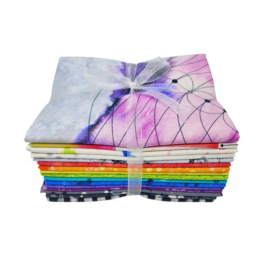 A stack of colorful folded patterned fabric pieces tied together with a sheer white ribbon, shown on a plain white background.