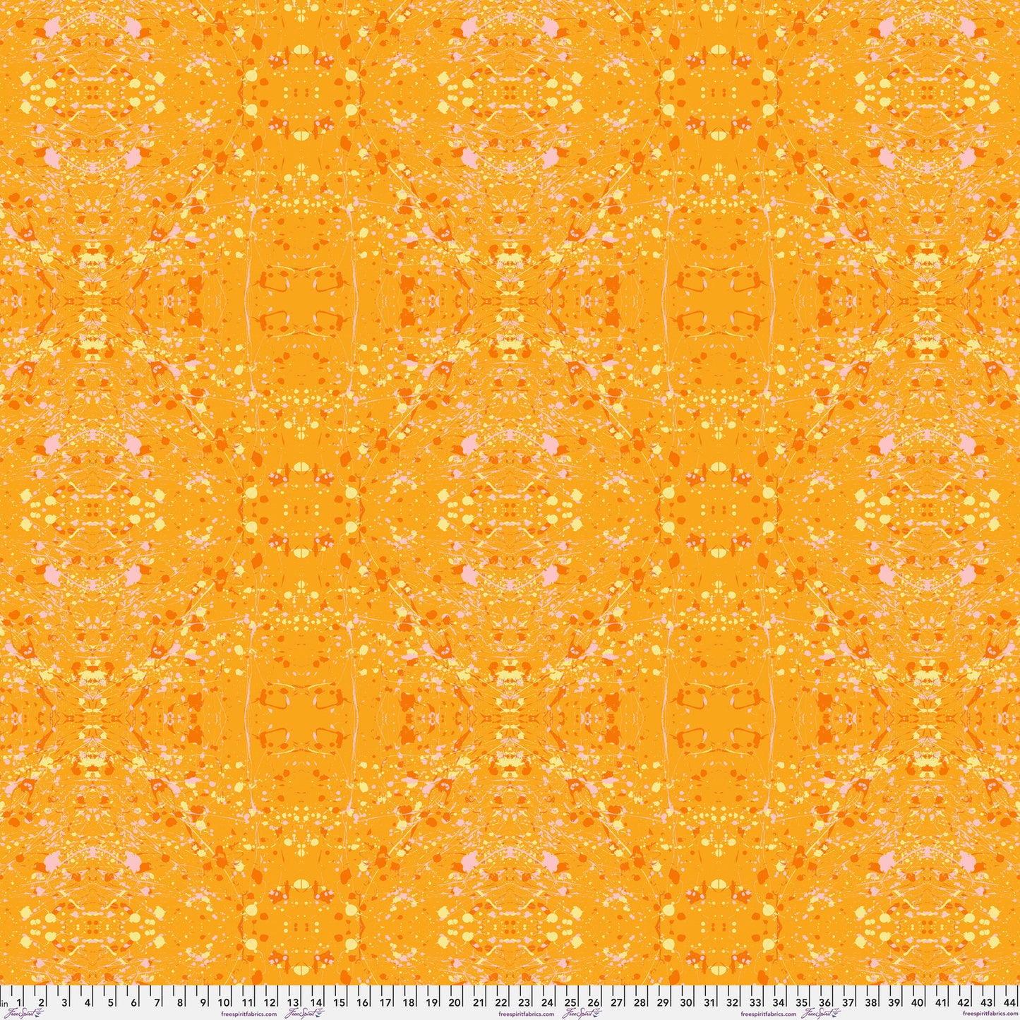 A seamless repeating fabric pattern featuring a symmetrical, kaleidoscopic design in vibrant orange, yellow, and soft pink tones. Ruler at the bottom for scale.