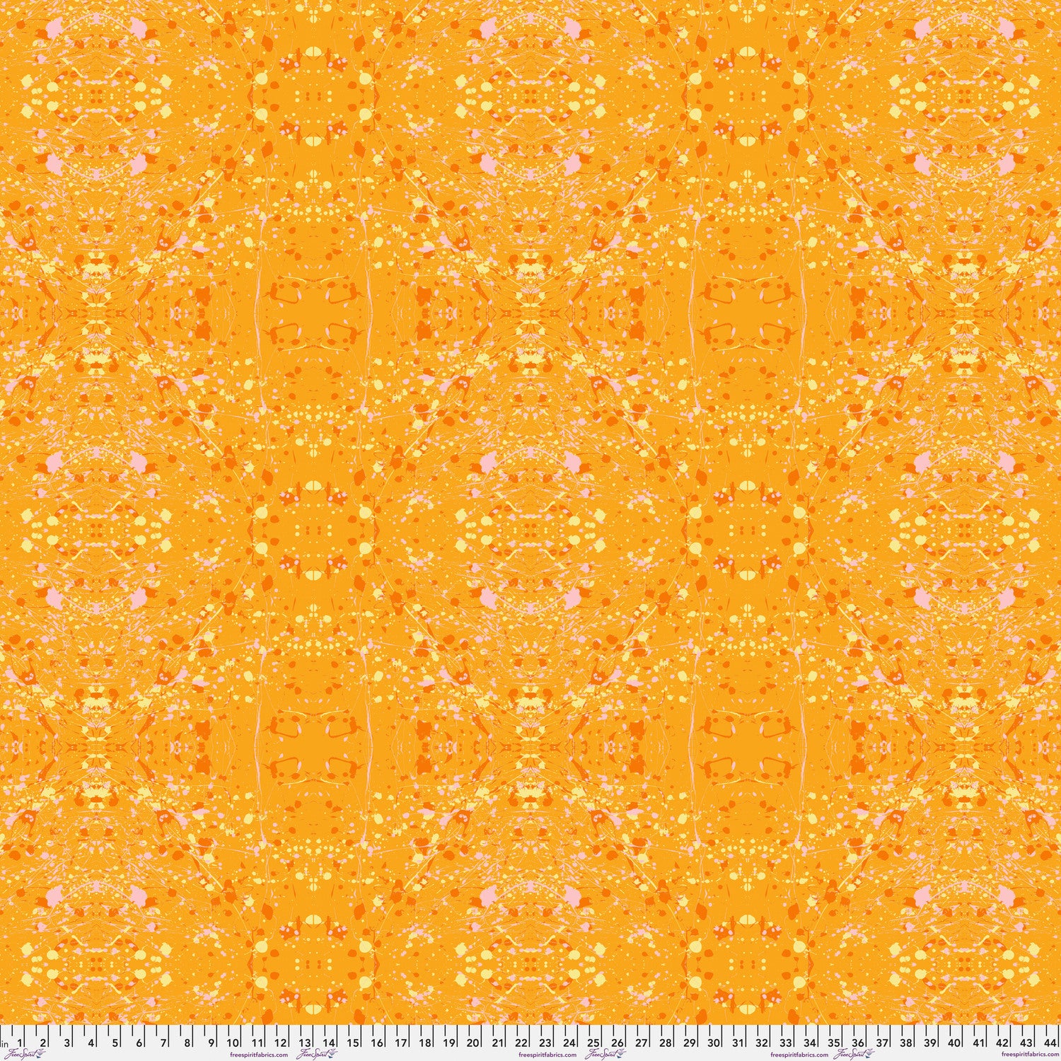 A seamless repeating fabric pattern featuring a symmetrical, kaleidoscopic design in vibrant orange, yellow, and soft pink tones. Ruler at the bottom for scale.