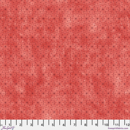 Fabric with a delicate allover geometric pattern of interlocking circles and starburst motifs on a tomato-red background. Ruler at the bottom for scale.