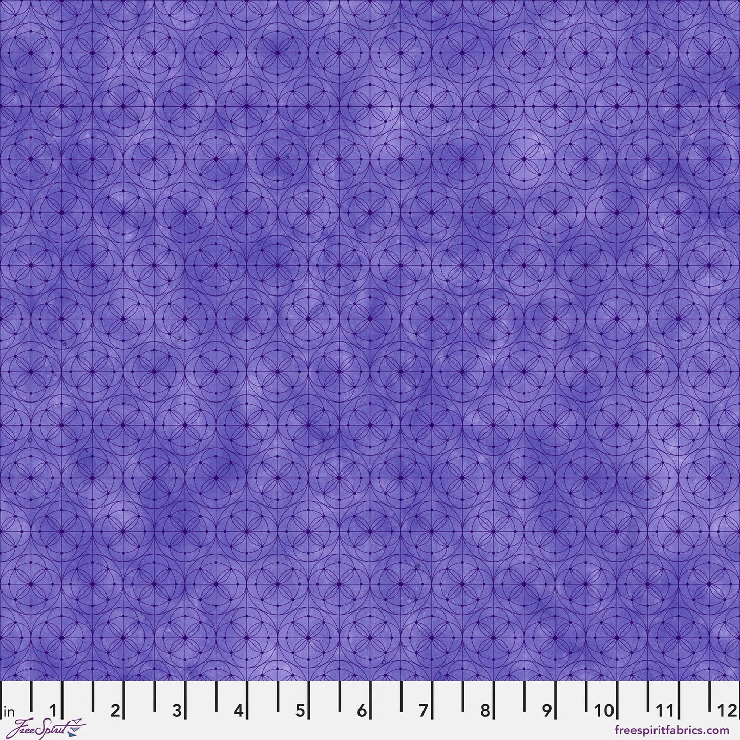 Purple fabric with a repeating geometric circle pattern, shown with a white ruler along the bottom edge for scale.