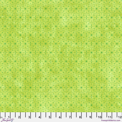 Fabric pattern featuring a repeating geometric design of interlocking circles and stars in lime green with a ruler along the bottom edge for scale.