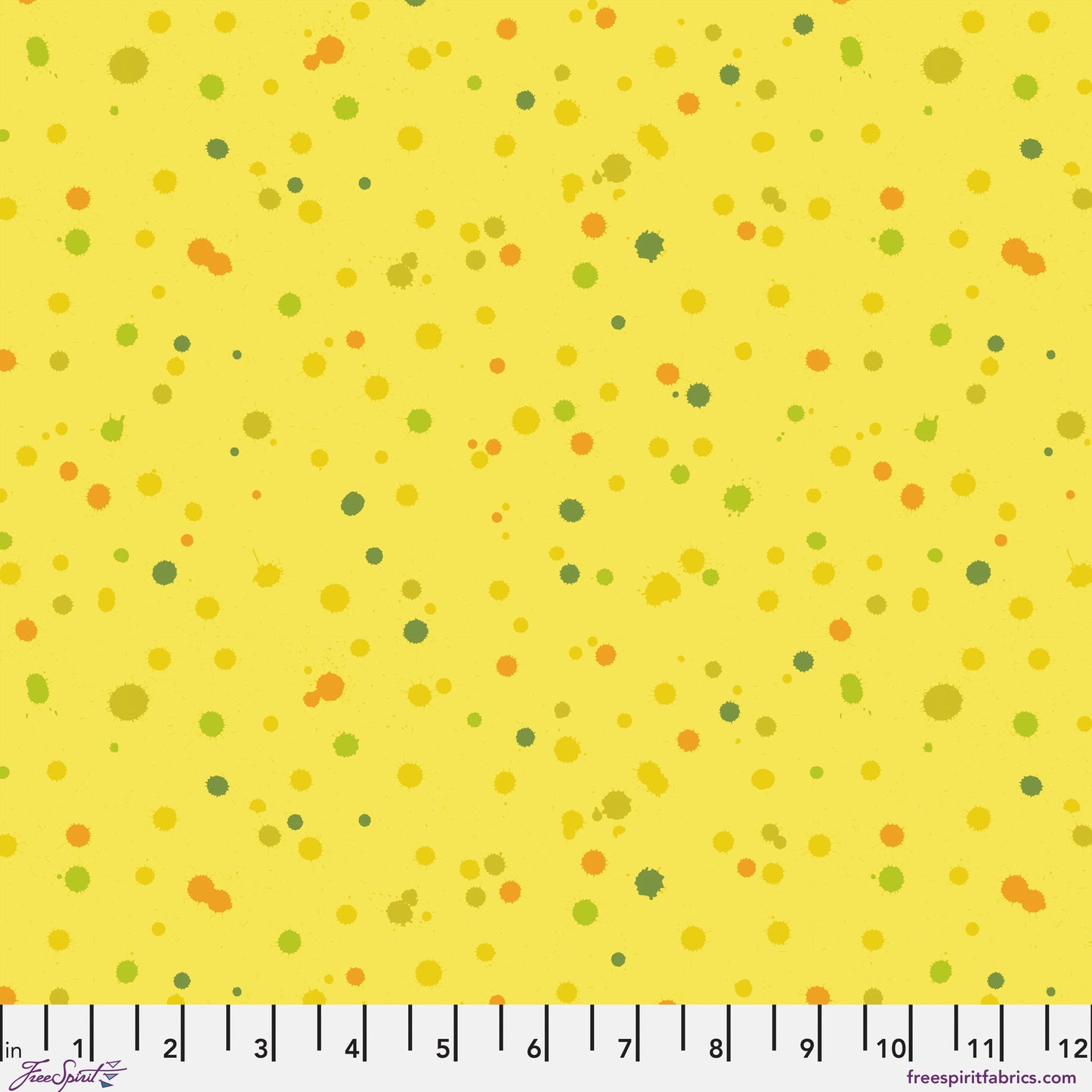 Fabric design of paint droplets in olive, orange, and chartreuse tones scattered across a warm, sunny yellow background. Ruler at the bottom for scale.
