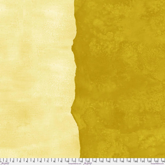 Abstract fabric pattern with a watercolor-like texture featuring lemon-yellow and soft, buttery-cream. Ruler at the bottom for scale.