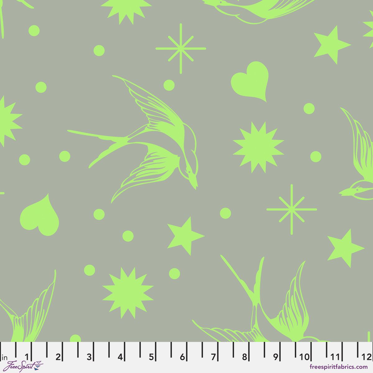 Neon Fairy Flakes in Karma features lime green swooping birds, stars, hearts, and dots tossed across a grey-green background. 12 inch ruler at the bottom for scale