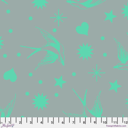 Neon Fairy Flakes in Spirit features teal swooping birds, stars, hearts, and dots tossed across a teal-grey background. 12 inch ruler at the bottom for scale