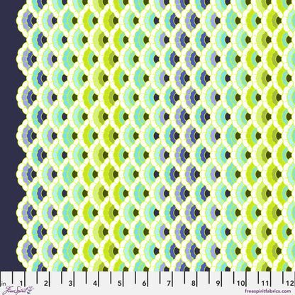 Geometric pattern of overlapping scalloped shapes with green, blue, navy, and turquoise colors on a dark background with a ruler for scale. 