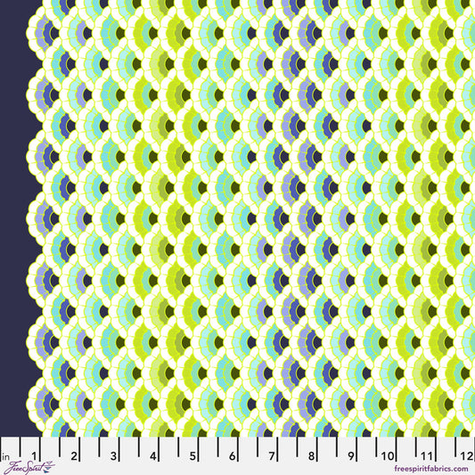Geometric pattern of overlapping scalloped shapes with green, blue, navy, and turquoise colors on a dark background with a ruler for scale. 