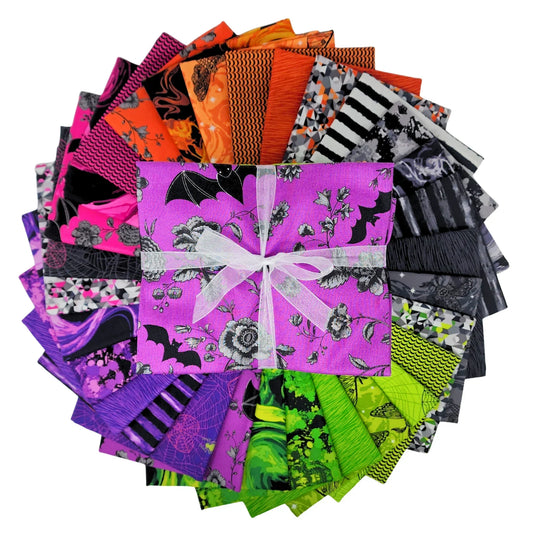 A fanned-out bundle of colorful fabric squares in vivid purples, oranges, greens, grays, and blacks, featuring floral designs, moths, spiderwebs, stripes, and abstract shapes with a Half-Yard Bundle in the center.