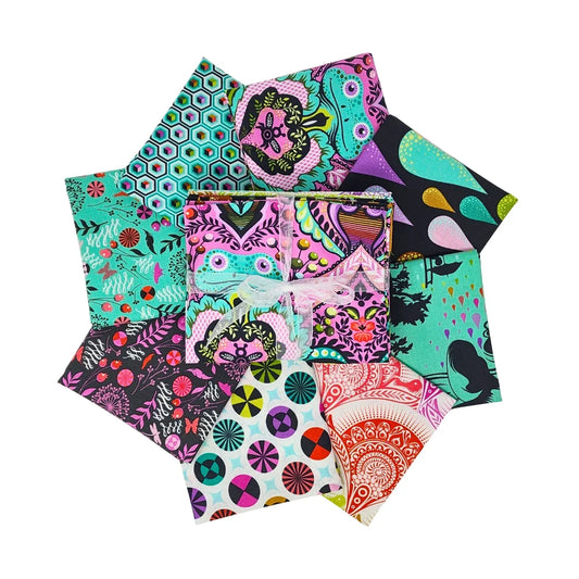 Circular arrangement of pink, teal, black, and white fabric swatches with geometric, floral, and animal designs a with a bundle tied with a white ribbon in the center.