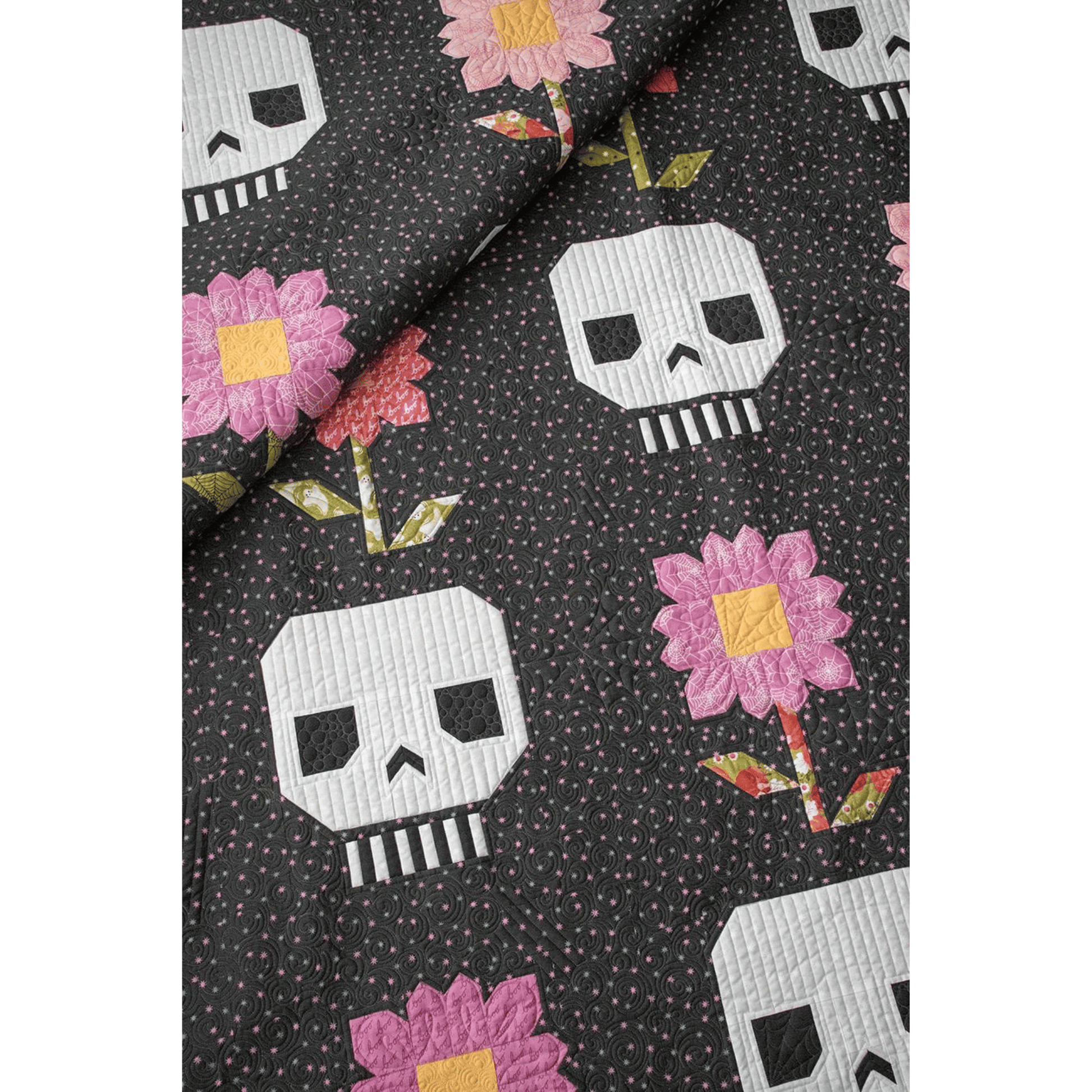 Pushing Up Daisies Quilt features alternating blocks of patchwork flowers and skulls.