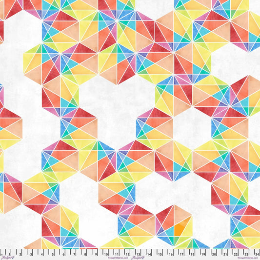 Fabric with a bold, graphic pattern of hexagons subdivided into vivid, multicolored triangles. Ruler at the bottom for scale.