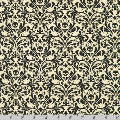 An ornate black damask pattern with small skull motifs on a soft, antique-white background with a ruler at the bottom for scale.