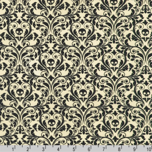 An ornate black damask pattern with small skull motifs on a soft, antique-white background with a ruler at the bottom for scale.