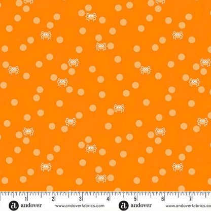Orange fabric with peach polka dots and small cartoon spiders with a ruler for scale