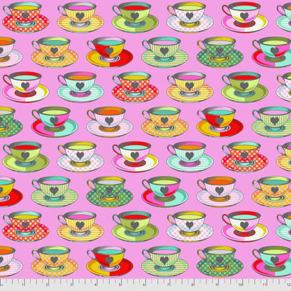 Pattern of colorful teacups and saucers on a pink background with a ruler for scale.