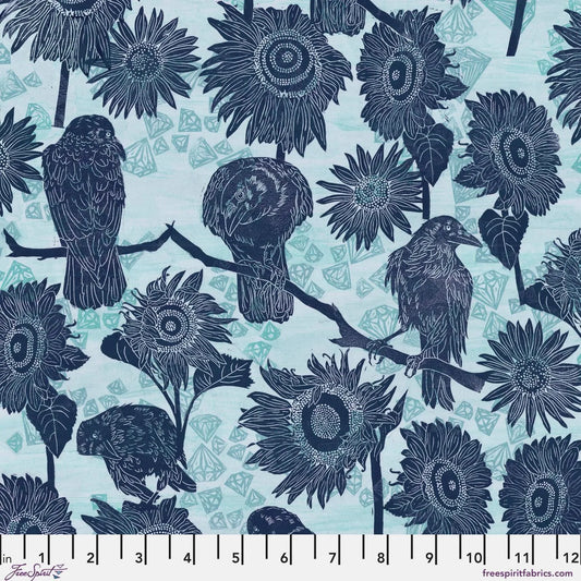 Pattern of navy blue birds and sunflowers on a powder blue background with a ruler for scale.