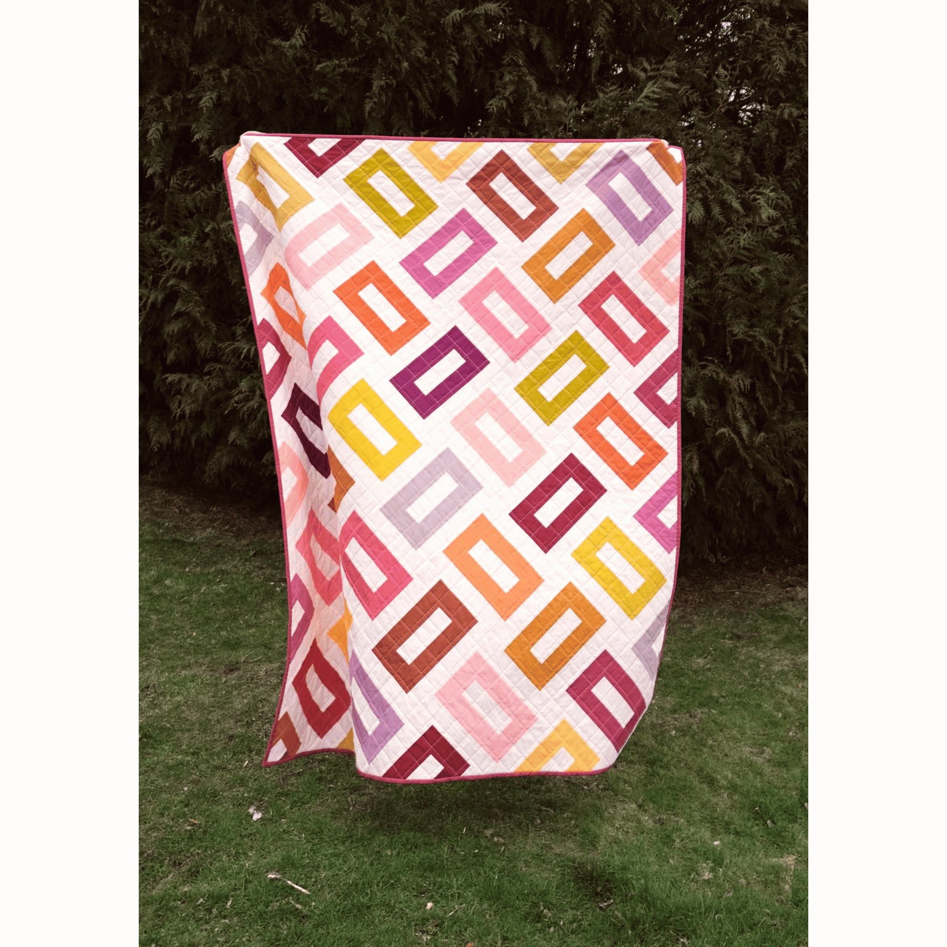 The Orla Quilt features hollow rectangles in pink, yellow, purple, and coral on a white background.