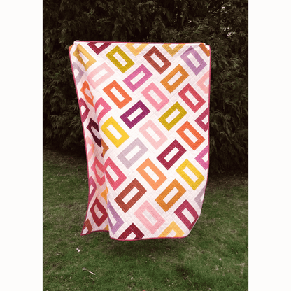 The Orla Quilt features hollow rectangles in pink, yellow, purple, and coral on a white background.