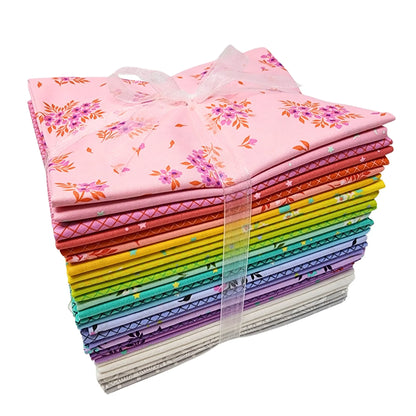 Stack of colorful fabric bundles tied with a ribbon on a white background