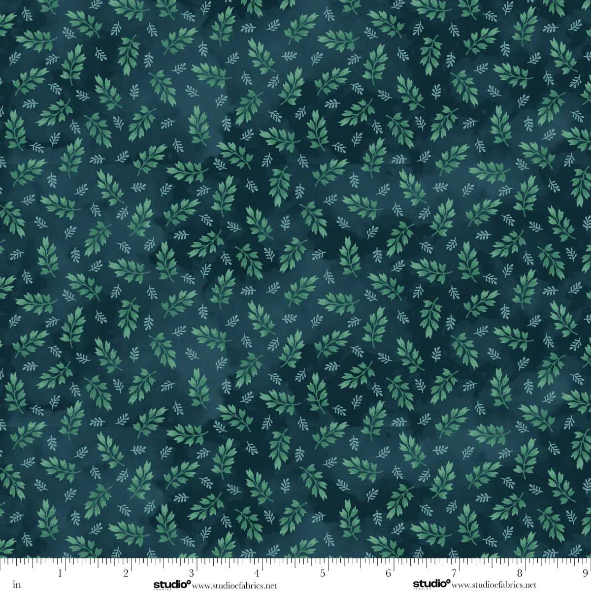Fabric with green leaf pattern on a dark blue background. Ruler at the bottom for scale.